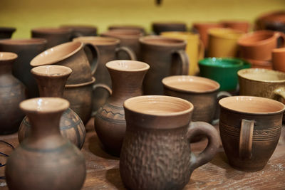 Many handmade clay jugs on the shelf in workshop