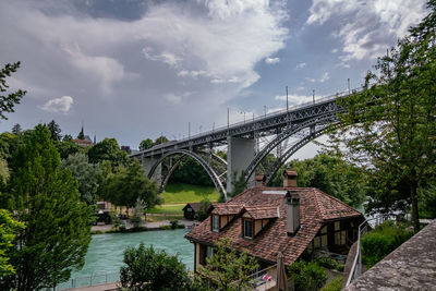 Bridge over river against cloudy sky