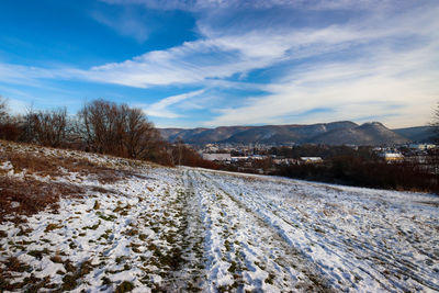 Scenic view of snow covered field against sky