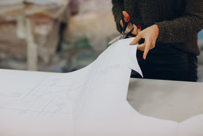 Midsection of woman holding paper outdoors