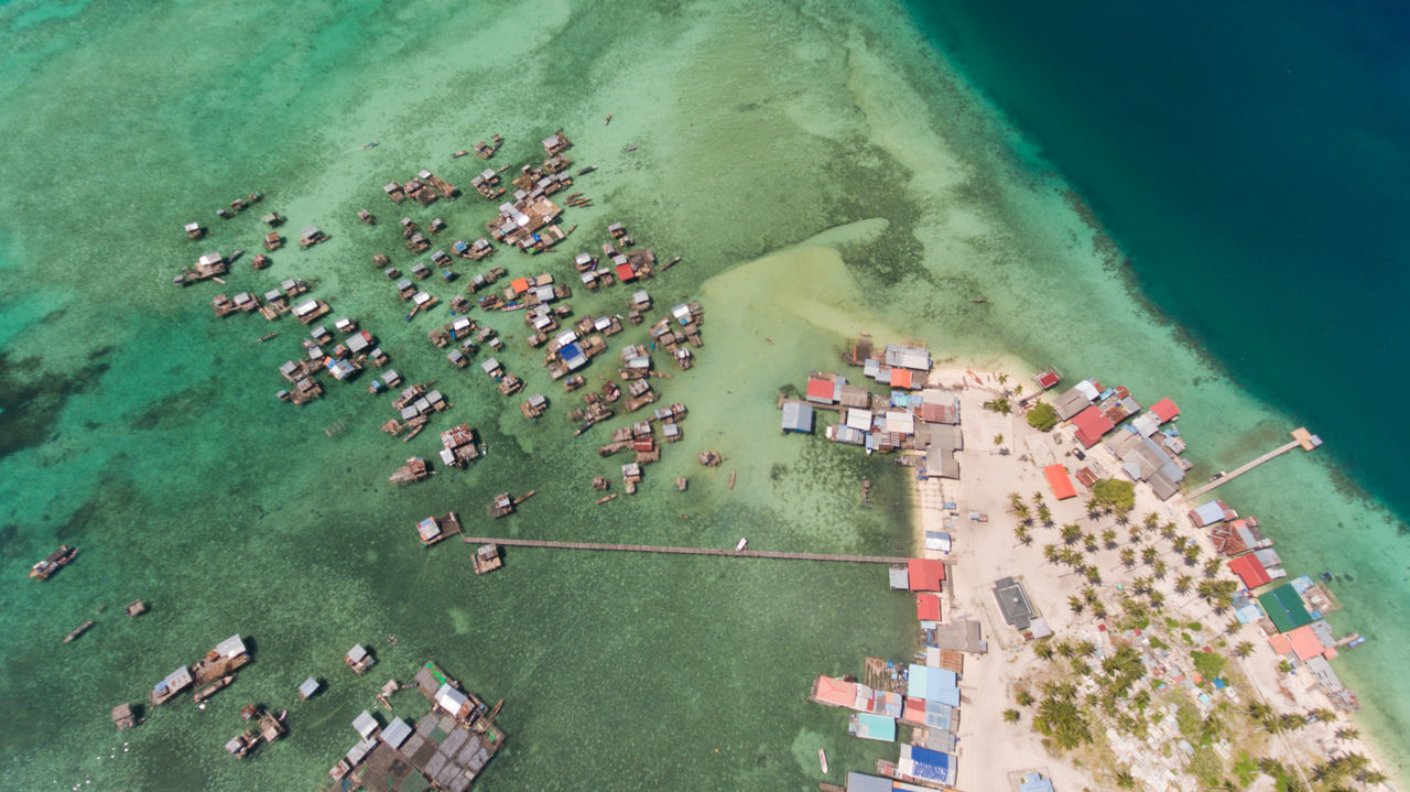 high angle view, water, aerial view, sea, architecture, day, nature, beach, outdoors, city, plant, no people, built structure, land, transportation, building exterior, holiday, swimming pool, turquoise colored