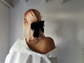 Rear view of woman against white wall