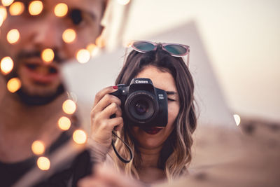 Portrait of woman photographing outdoors