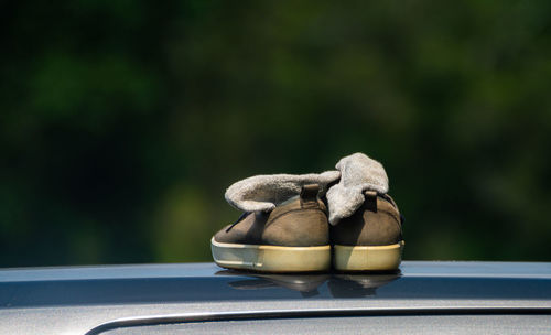 Close-up of shoes on car roof