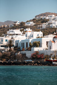 Buildings by sea against sky