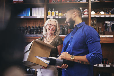 Coworkers smiling while working in delicatessen