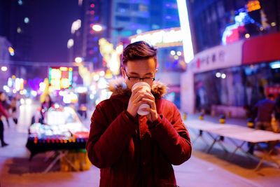 Portrait of man using mobile phone at city street