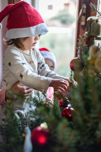 Side view of girl dexorating  christmas tree