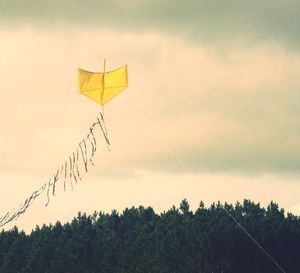 Low angle view of yellow flag against sky