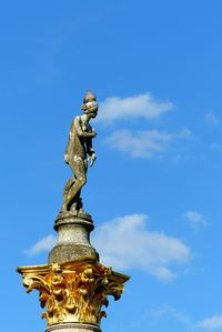 Low angle view of statue against blue sky