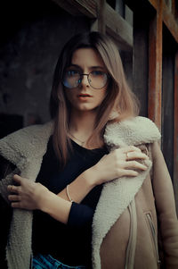 Portrait of young woman looking away while sitting at home
