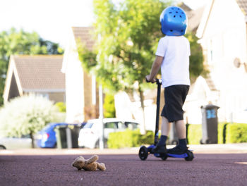 Full length of boy standing on push scooter outdoor