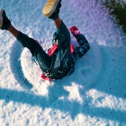 High angle view of man lying down on snow