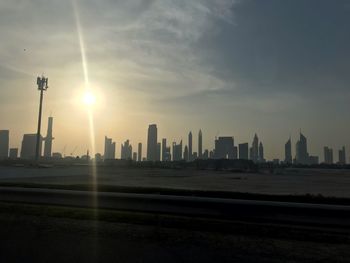Modern buildings in city against sky during sunset