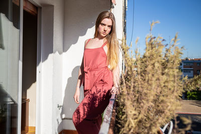 Young woman standing against built structure