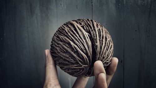 Midsection of person holding umbrella against wall