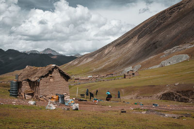 Hut by mountain on field