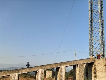 Low angle view of bridge against clear blue sky