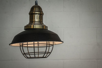 Close-up of illuminated electric lamp against wall