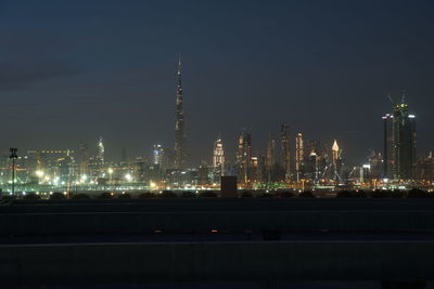 Illuminated city against sky at night