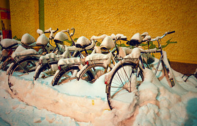 Bicycle parked against yellow wall