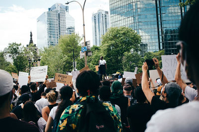 Rear view of people on street against buildings