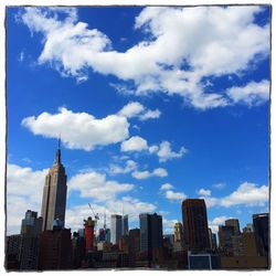 Modern cityscape against cloudy sky