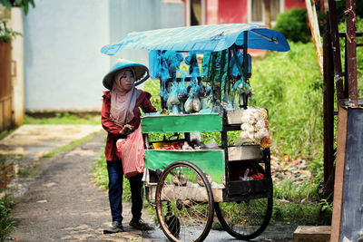 Rear view of woman sitting on street