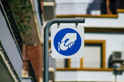 Close-up of road sign against blue wall