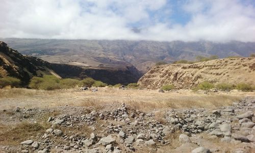 Scenic view of mountains against cloudy sky