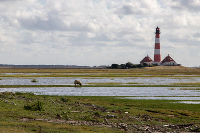 View of lighthouse on field against sky