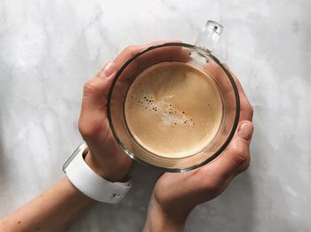 High angle view of hand holding coffee cup