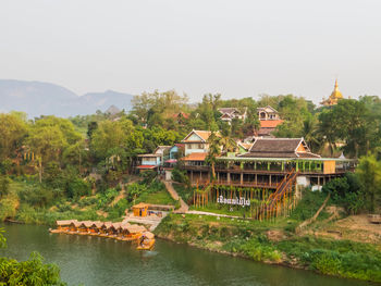 Houses by lake against sky