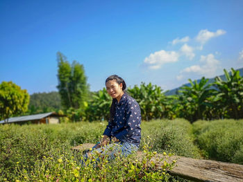 Young woman standing in farm against sky