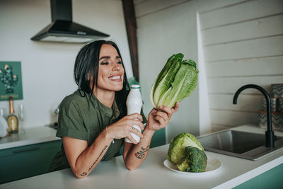 Woman smiling with arms raised at home