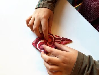 Cropped hands of woman making origami on table