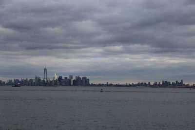 Buildings in city against cloudy sky