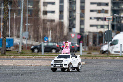 Little girldriving a toy car. little driver, childrens car, concept of road safety, children in car