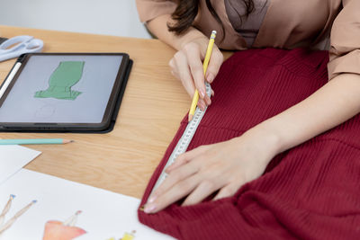 Midsection of woman using digital tablet