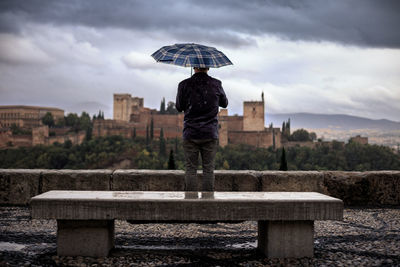 Rear view of man standing on rainy day