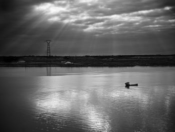 Scenic view of river against cloudy sky