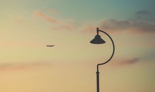 Low angle view of silhouette bird flying against sky during sunset