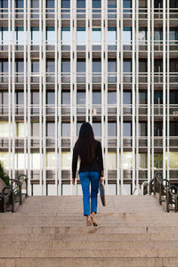 Full length rear view of woman walking in city