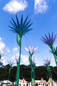 Low angle view of palm trees against blue sky