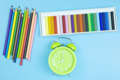 Close-up of multi colored pencils on table against blue background