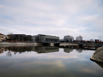 Reflection of buildings in river against sky