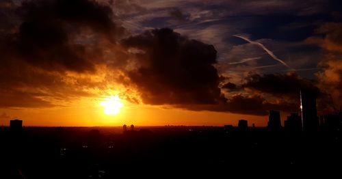 Silhouette cityscape against sky during sunset