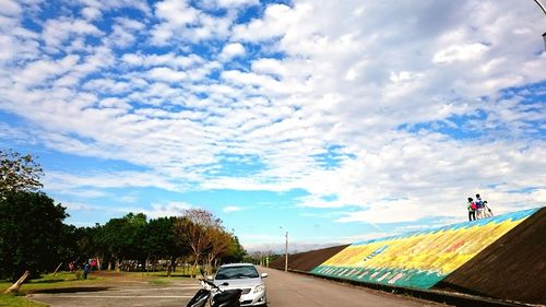 Man riding bicycle on road against sky