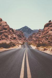 Empty road leading towards mountain