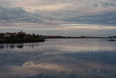 Reflection of buildings in lake during sunset